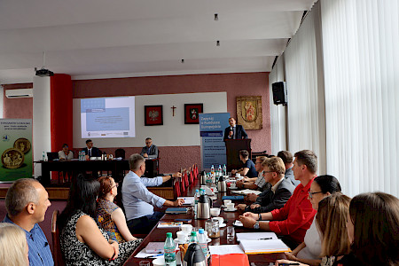 Mężczyźni i kobiety siedzą w sali konferencyjnej