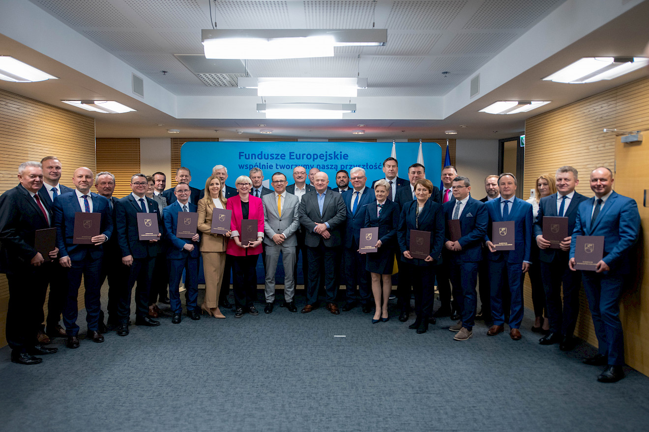 Kilkadziesiąt osób w różnym wieku i różnej płci pozuje do pamiątkowe fotografii