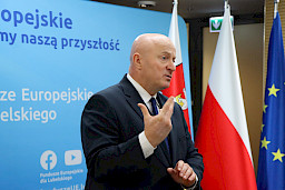Marszałek Województwa Lubelskiego, Pan Jarosław Stawiarski przemawia na tle ścianki Fundusze Europejskie dla Lubelskiego i flag: Unii Europejskiej, Polski i Województwa Lubelskiego.