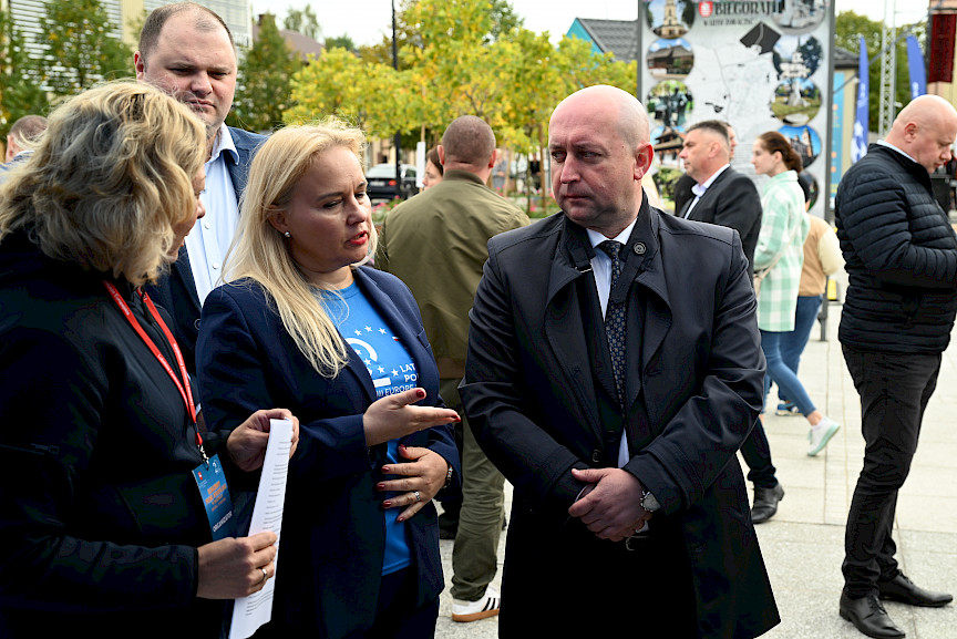 2024 r. Biłgoraj. Marszałek Piotr Breś oraz Pani Dyrektor Departamentu Zarządzania Programami Regionalnymi stoją przed Punktem Informacyjnym Funduszy Europejskich