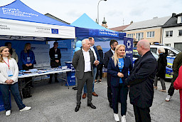 2024 r. Biłgoraj. Marszałek Piotr Breś oraz Pani Dyrektor Departamentu Zarządzania Programami Regionalnymi stoją przed Punktem Informacyjnym Funduszy Europejskich