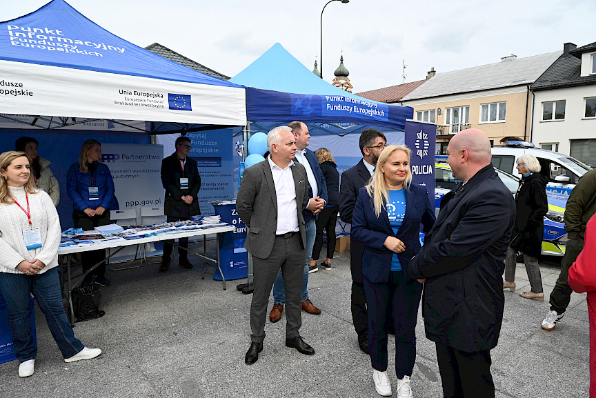 2024 r. Biłgoraj. Marszałek Piotr Breś oraz Pani Dyrektor Departamentu Zarządzania Programami Regionalnymi stoją przed Punktem Informacyjnym Funduszy Europejskich