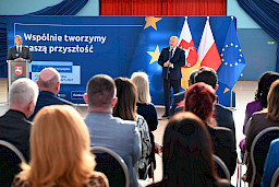 Uroczyste wręczenie umów z Działania 10.4 w Radzyniu Podlaskim w dniu 21.10.2024 r. Marszałek na tle ścianki funduszy europejskich przemawia do zgromadzonych gości.