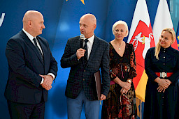 Uroczyste wręczenie umów z Działania 10.4 w Radzyniu Podlaskim w dniu 21.10.2024 r. Na tle ścianki funduszy europejskich stoi Marszałek Jarosław Stawiarski oraz beneficjent z wręczoną umową.