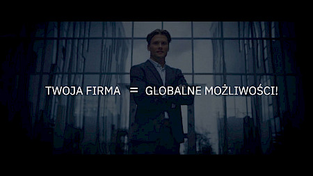 Napis Twoja firma = globalne możliwości na tle stojącego człowieka w garniturze