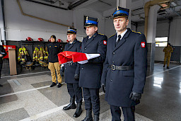 Uroczyste przekazanie sprzętu Straży Pożarnej w Kraśniku, strażacy przygotowują flagę do uroczystego wciągnięcia.