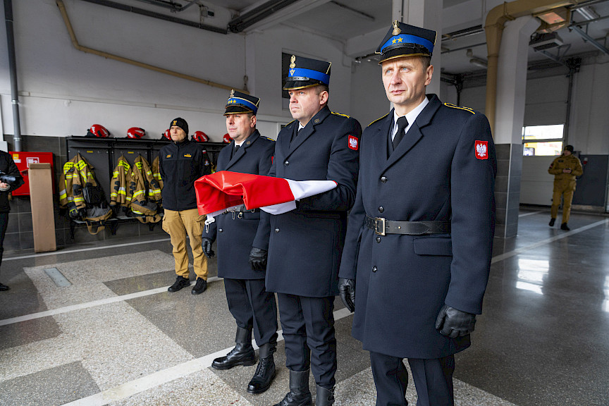 Uroczyste przekazanie sprzętu Straży Pożarnej w Kraśniku, strażacy przygotowują flagę do uroczystego wciągnięcia.