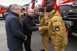 Uroczyste przekazanie sprzętu Straży Pożarnej w Kraśniku, Wicemarszałek Piotr Breś wręcza kluczyki oraz dokumenty strażakom do wozu strażackiego.