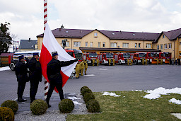 Uroczyste wręczenie sprzętu Straży Pożarnej. Wciagnięcie flagi Polski na maszt podczas hymnu narodowego.