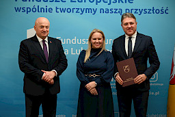 Uroczyste wręczenie umów o dofinansowanie projektów z funduszy europejskich na Integrację społeczną osób najbardziej potrzebujących wsparcia. Marszałek Jarosław Stawiarski z Beneficjentem projektu, który trzyma wręczoną umowę w dłoni.