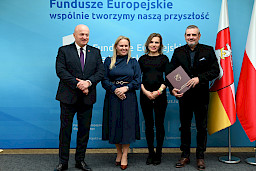 Uroczyste wręczenie umów o dofinansowanie projektów z funduszy europejskich na Integrację społeczną osób najbardziej potrzebujących wsparcia. Marszałek Jarosław Stawiarski z Beneficjentem projektu, który trzyma wręczoną umowę w dłoni.