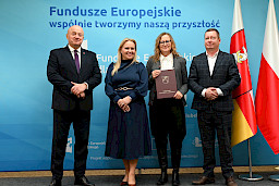 Uroczyste wręczenie umów o dofinansowanie projektów z funduszy europejskich na Integrację społeczną osób najbardziej potrzebujących wsparcia. Marszałek Jarosław Stawiarski z Beneficjentem projektu, który trzyma wręczoną umowę w dłoni.