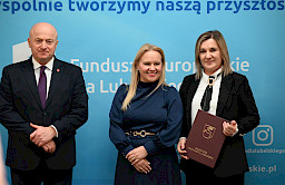 Uroczyste wręczenie umów o dofinansowanie projektów z funduszy europejskich na Integrację społeczną osób najbardziej potrzebujących wsparcia. Marszałek Jarosław Stawiarski z Beneficjentem projektu, który trzyma wręczoną umowę w dłoni.