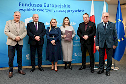 Uroczyste wręczenie umów o dofinansowanie projektów z funduszy europejskich na Integrację społeczną osób najbardziej potrzebujących wsparcia. Marszałek Jarosław Stawiarski z Beneficjentem projektu, który trzyma wręczoną umowę w dłoni.