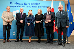 Uroczyste wręczenie umów o dofinansowanie projektów z funduszy europejskich na Integrację społeczną osób najbardziej potrzebujących wsparcia. Marszałek Jarosław Stawiarski z Beneficjentem projektu, który trzyma wręczoną umowę w dłoni.