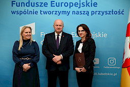 Uroczyste wręczenie umów o dofinansowanie projektów z funduszy europejskich na Integrację społeczną osób najbardziej potrzebujących wsparcia. Marszałek Jarosław Stawiarski z Beneficjentem projektu, który trzyma wręczoną umowę w dłoni.