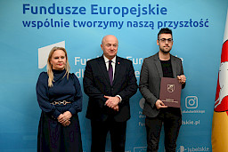 Uroczyste wręczenie umów o dofinansowanie projektów z funduszy europejskich na Integrację społeczną osób najbardziej potrzebujących wsparcia. Marszałek Jarosław Stawiarski z Beneficjentem projektu, który trzyma wręczoną umowę w dłoni.