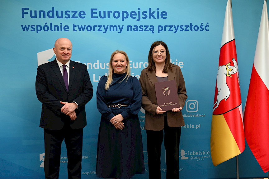Uroczyste wręczenie umów o dofinansowanie projektów z funduszy europejskich na Integrację społeczną osób najbardziej potrzebujących wsparcia. Marszałek Jarosław Stawiarski z Beneficjentem projektu, który trzyma wręczoną umowę w dłoni.