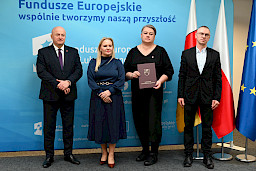 Uroczyste wręczenie umów o dofinansowanie projektów z funduszy europejskich na Integrację społeczną osób najbardziej potrzebujących wsparcia. Marszałek Jarosław Stawiarski z Beneficjentem projektu, który trzyma wręczoną umowę w dłoni.