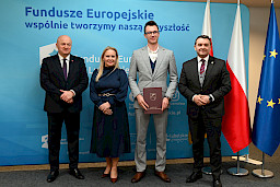 Uroczyste wręczenie umów o dofinansowanie projektów z funduszy europejskich na Integrację społeczną osób najbardziej potrzebujących wsparcia. Marszałek Jarosław Stawiarski z Beneficjentem projektu, który trzyma wręczoną umowę w dłoni.