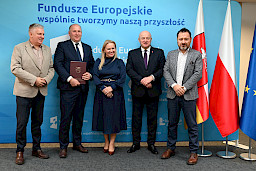 Uroczyste wręczenie umów o dofinansowanie projektów z funduszy europejskich na Integrację społeczną osób najbardziej potrzebujących wsparcia. Marszałek Jarosław Stawiarski z Beneficjentem projektu, który trzyma wręczoną umowę w dłoni.