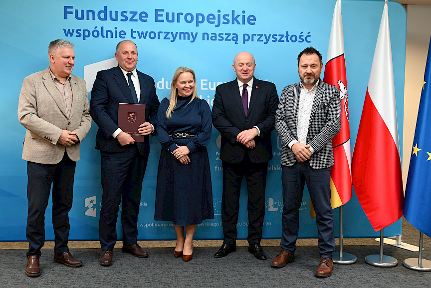 Uroczyste wręczenie umów o dofinansowanie projektów z funduszy europejskich na Integrację społeczną osób najbardziej potrzebujących wsparcia. Marszałek Jarosław Stawiarski z Beneficjentem projektu, który trzyma wręczoną umowę w dłoni.