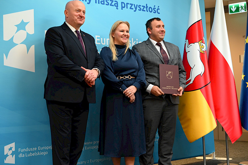 Uroczyste wręczenie umów o dofinansowanie projektów z funduszy europejskich na Integrację społeczną osób najbardziej potrzebujących wsparcia. Marszałek Jarosław Stawiarski z Beneficjentem projektu, który trzyma wręczoną umowę w dłoni.