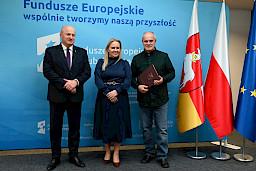 Uroczyste wręczenie umów o dofinansowanie projektów z funduszy europejskich na Integrację społeczną osób najbardziej potrzebujących wsparcia. Marszałek Jarosław Stawiarski z Beneficjentem projektu, który trzyma wręczoną umowę w dłoni.