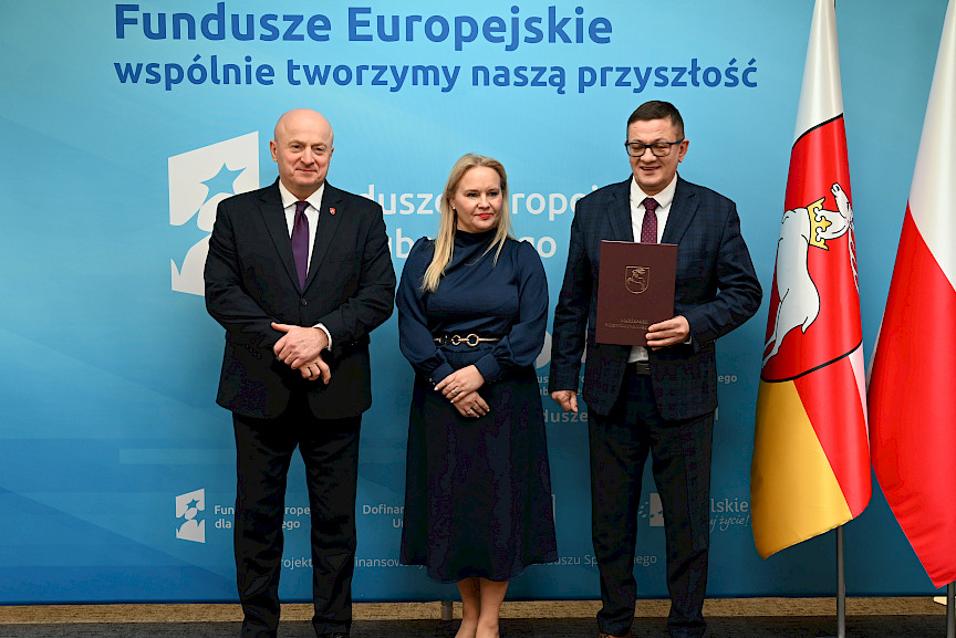 Uroczyste wręczenie umów o dofinansowanie projektów z funduszy europejskich na Integrację społeczną osób najbardziej potrzebujących wsparcia. Marszałek Jarosław Stawiarski z Beneficjentem projektu, który trzyma wręczoną umowę w dłoni.