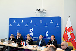 XVII Posiedzenie grup roboczych działających przy Komitecie Monitorującym Fundusze Europejskie dla Lubelskiego 2021-2027, na zdjęciu prezydium, w tle ścianka Funduszy Europejskich i flaga Województwa Lubelskiego.