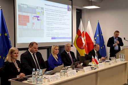 XX posiedzenie Komitetu Monitorującego Fundusze Europejskie dla Lubelskiego 2021-2027 (KM FEL) w dniu 17 marca 2025 r. Sala posiedzeń. Za stołem Marszałek Jarosław Stawiarski oraz członkowie prezydium. Za nimi prezentacja wskaźników z realizowanego projekt