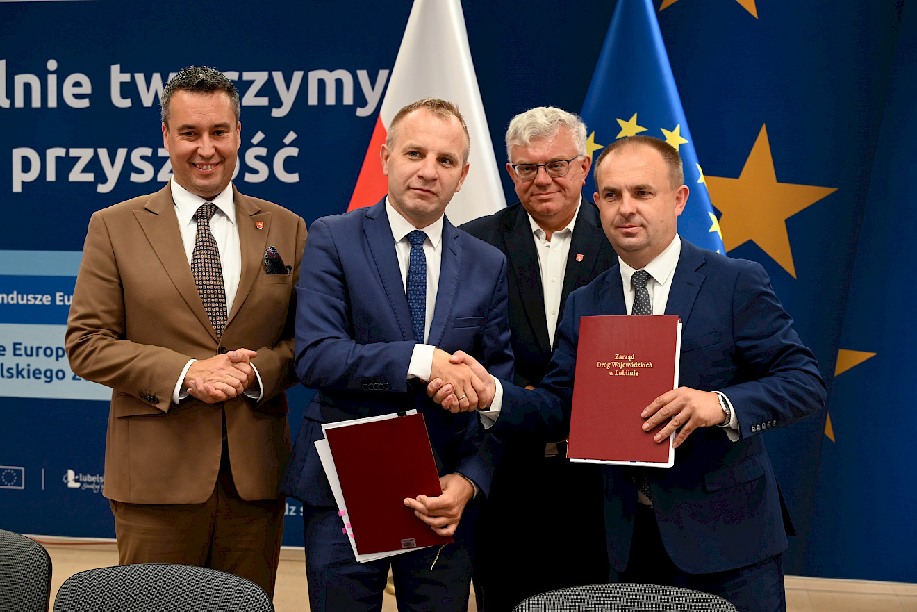 Podpisanie umowy pomiędzy Zarządem Dróg Wojewódzkich w Lublinie a firmą STRABAG Sp. z o. o na przebudowę ponad 9 km drogi wojewódzkiej nr 812 na odcinku Żuków - Korolówka. Przedstawiciel ZDW i STRABAG pozują z podpisaną umową.