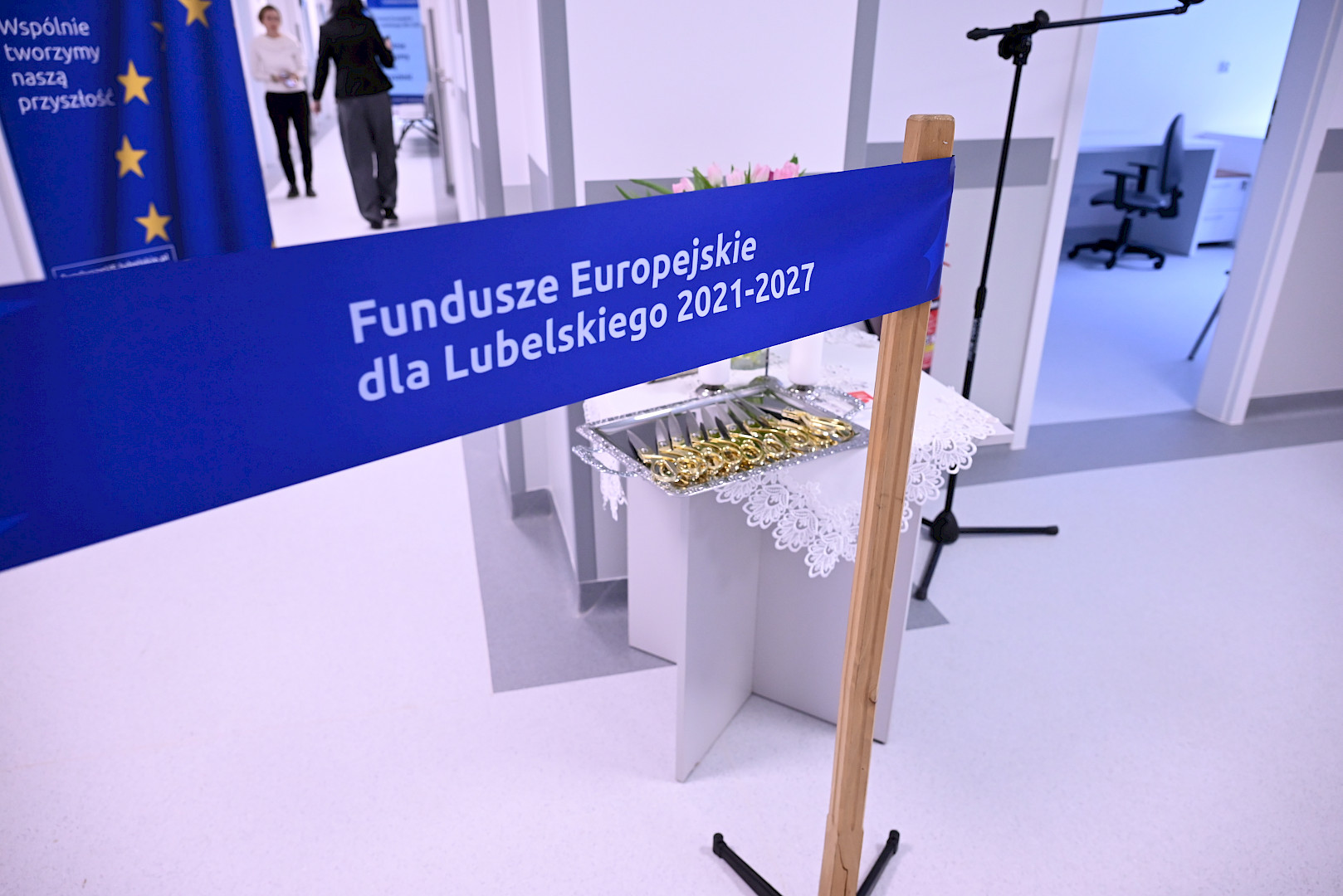 Ujęcie symbolicznej taśmy otwarcia oddziału. Kolor niebieski z napisem Fundusze Europejskie dla Lubelskiego 2021 2027
