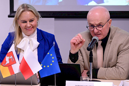 Marszałek Województwa Lubelskiego Jarosław Stawiarski wypowiada się do mikrofonu. Po jego prawej stronie dzieci Dyrektor Departamentu Zarządzania Programami Regionalnymi Anna Brzyska.