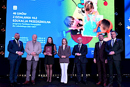 Zdjęcie Zarządu Województwa Lubelskiego z beneficjentką projektu. Kobieta trzyma teczkę z umową.