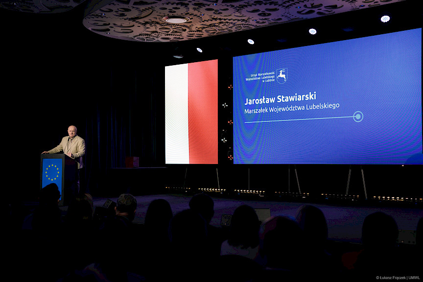 Marszałek Województwa Lubelskiego Jarosław Stawiarski wypowiada się do mikrofonu przy ambonie.