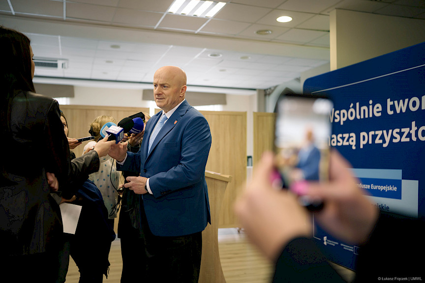 Marszałek Jarosław Stawiarski udziela wywiadu mediom do mikrofonów.