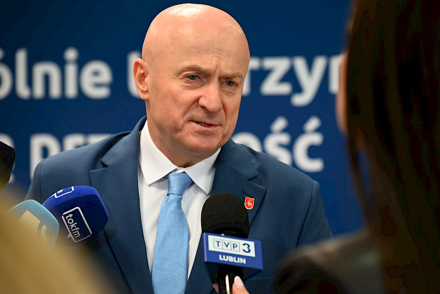 Marszałek Jarosław Stawiarski udziela wywiadu mediom do mikrofonów. Ujęcie z bliska jest twarzy.