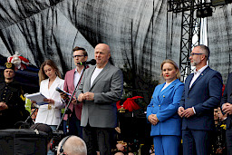 Marszałek Województwa Lubelskiego przemawia ze sceny. Obok niego stoi Dyrektor Anna Brzyska, Burmistrz Miasta Łęczna oraz prowadzący wydarzenie.