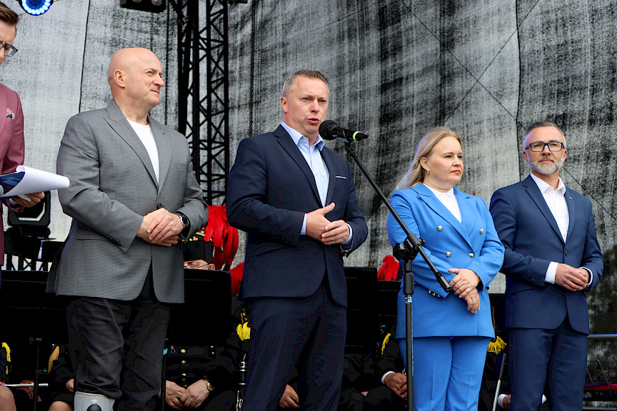 Przedstawiciel gminy Łęczna wypowiada się na scenie do mikrofonu, obok niego stoi Marszałek Jarosław Stawiarski oraz Dyrektor Anna Brzyska.