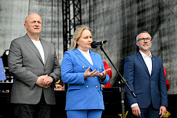 Dyrektor Departamentu Zarządzania Programami Regionalnymi Anna Brzyska przemawia ze sceny do mikrofonu. Obok niej stoi Marszałek Jarosław Stawiarski oraz Burmistrz Miasta Łęcznej.