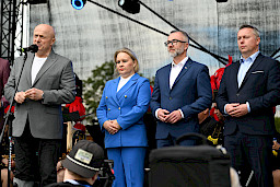 Marszałek Województwa Lubelskiego przemawia ze sceny. Obok niego stoi Dyrektor Anna Brzyska oraz Przedstawiciele Miasta Łęczna.