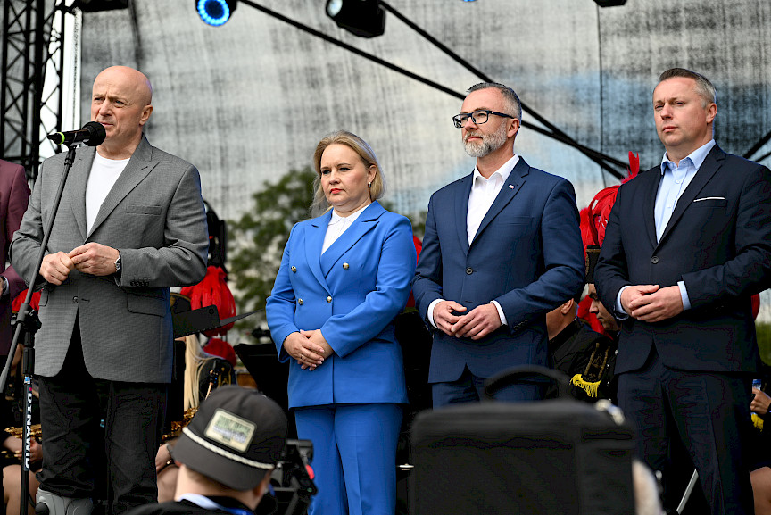 Marszałek Województwa Lubelskiego przemawia ze sceny. Obok niego stoi Dyrektor Anna Brzyska oraz Przedstawiciele Miasta Łęczna.
