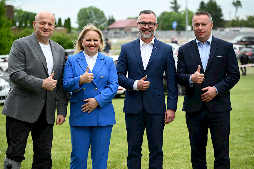 Marszałek Województwa Lubelskiego Jarosław Stawiarski pozuje do zdjęcia z Dyrektor Departamentu Zarządzania Programami Regionalnymi Anną Brzyską oraz przedstawicielami Miasta Łęczna. Pokazują wszyscy kciuk w górę i uśmiechają się.
