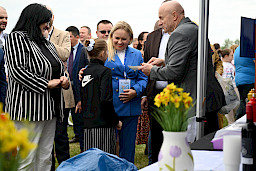 Marszałek Województwa Lubelskiego - Jarosław Stawiarski oraz Anna Brzyska Dyrektor DZ PR rozmawiają z dziewczynka. W tle tłum ludzi.
