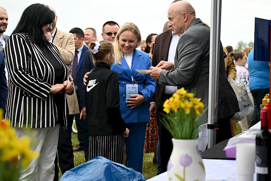 Marszałek Województwa Lubelskiego - Jarosław Stawiarski oraz Anna Brzyska Dyrektor DZ PR rozmawiają z dziewczynka. W tle tłum ludzi.