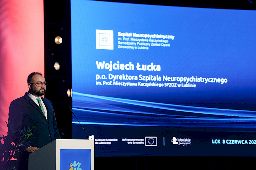 Dyrektor Szpitala Neuropsychiatrycznego Wojciech Łucka wypowiada się przy ambonie do mikrofonu.
