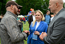 Pan Marszałek i Pani Dyrektor Anna Brzyska rozmawiają z Tomaszem Jacyków. W tle tłum ludzi.