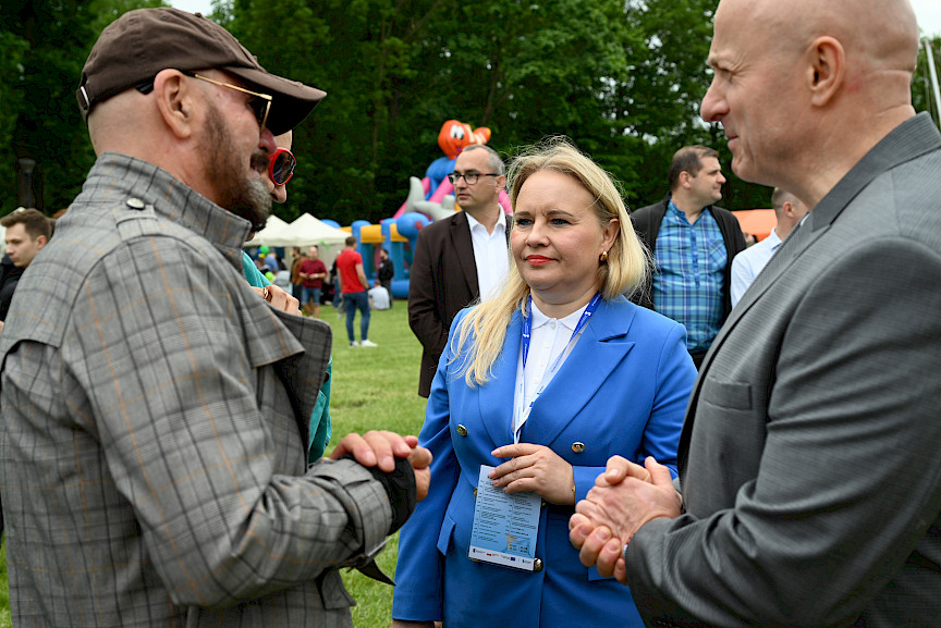 Pan Marszałek i Pani Dyrektor Anna Brzyska rozmawiają z Tomaszem Jacyków. W tle tłum ludzi.
