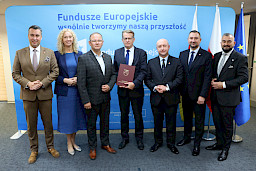 Przedstawiciele Zarządu Województwa Lubelskiego pozują do zdjęcia z beneficjentami projektu.